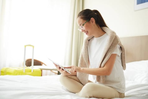 Woman in hotel room looking at tablet