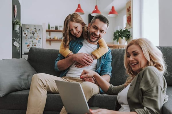 Family gathered around laptop