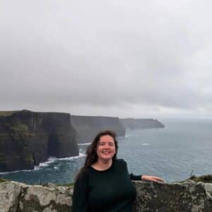Carly Fielding, Marketing Assistant, standing at the Cliffs of Moher in Ireland