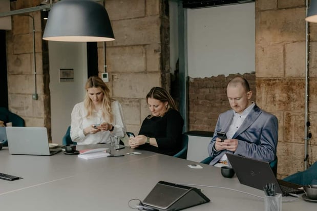 Group of people on their phones during meeting