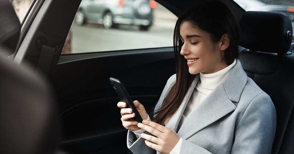Woman in car looking at cellphone
